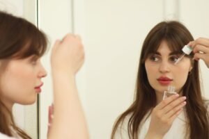 Two people applying skincare products at a bathroom mirror
