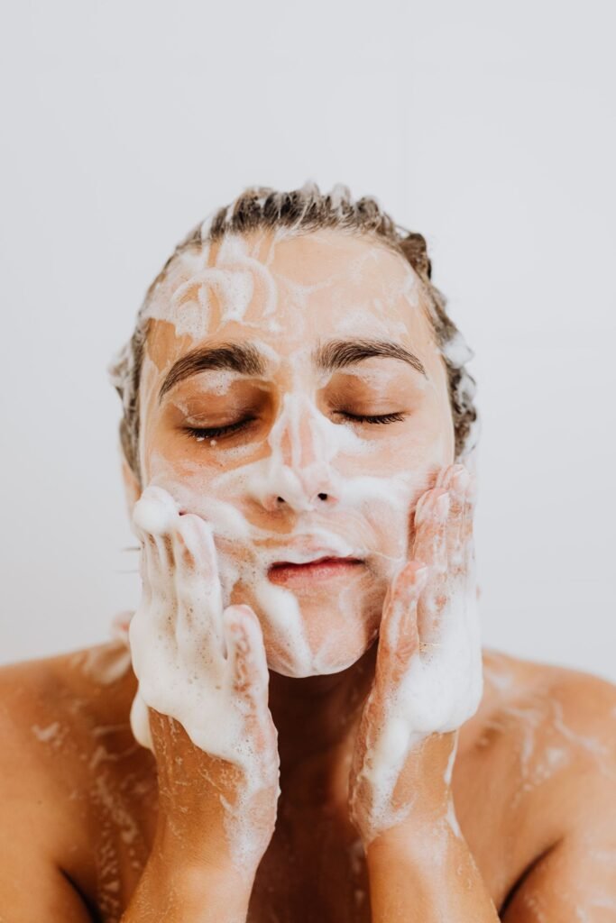 A person washing their face with a foaming cleanser