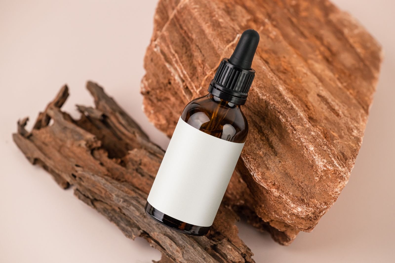 pexels-photo-12572315 - The Skincare Space Amber dropper bottle with a blank, unprinted label resting on wood
